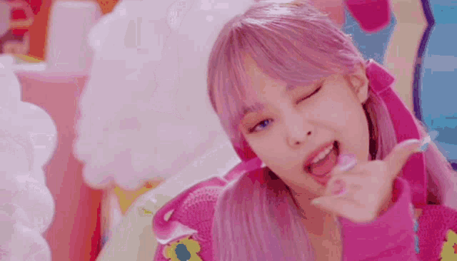 a girl with pink hair is making a funny face while wearing a pink jacket .