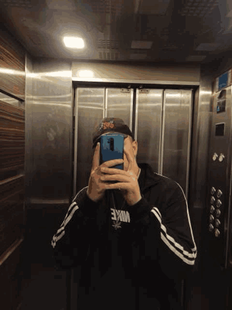 a man is taking a selfie in an elevator .