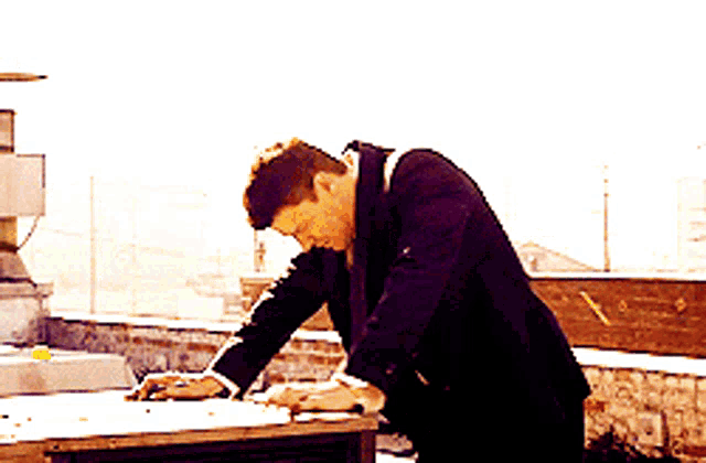 a man in a suit is writing on a table