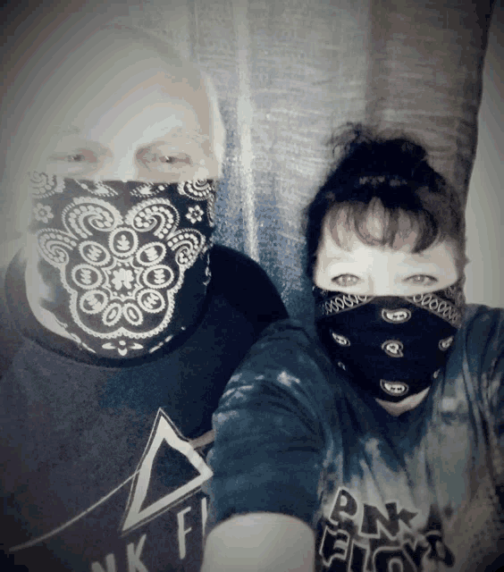 a man and a woman wearing face masks and a pink floyd shirt
