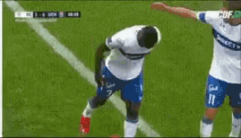 a soccer player is dancing on the field while another player watches .