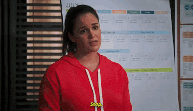 a woman is standing in front of a calendar that says july