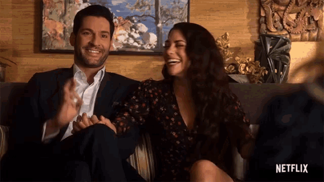 a man and a woman are sitting on a couch with the netflix logo in the corner