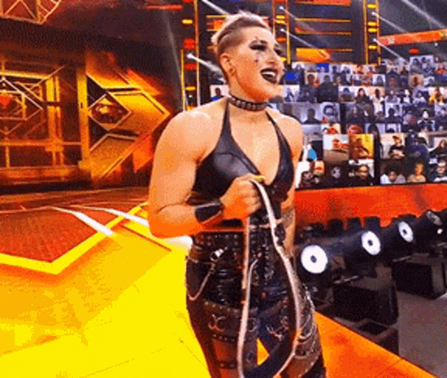 a woman is holding a rope on a stage with a crowd in the background