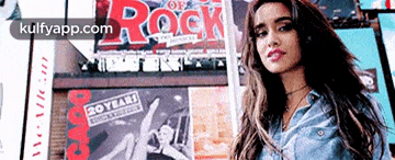 a woman is standing in front of a sign that says 20 years of rock