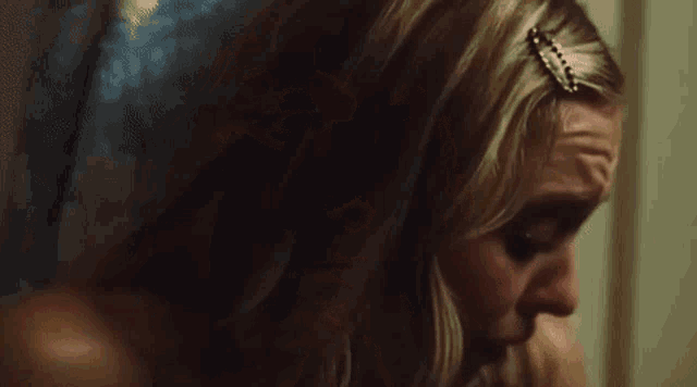 a close up of a woman 's face with a shocked expression on her face .