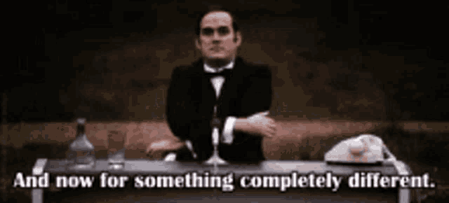 a man in a tuxedo sits at a desk with the words and now for something completely different on the bottom