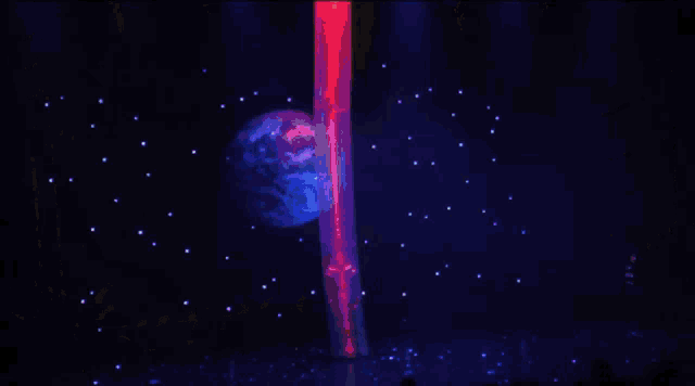 a group of people are watching a stage show with a planet in the background
