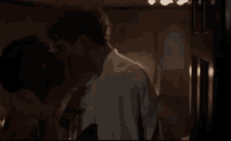 a man and a woman are kissing in a dark room in a room .
