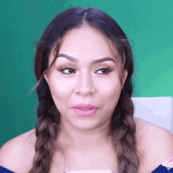 a woman with braids on her hair is making a funny face