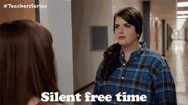 a woman in a plaid shirt is standing next to another woman in a hallway and says silent free time .