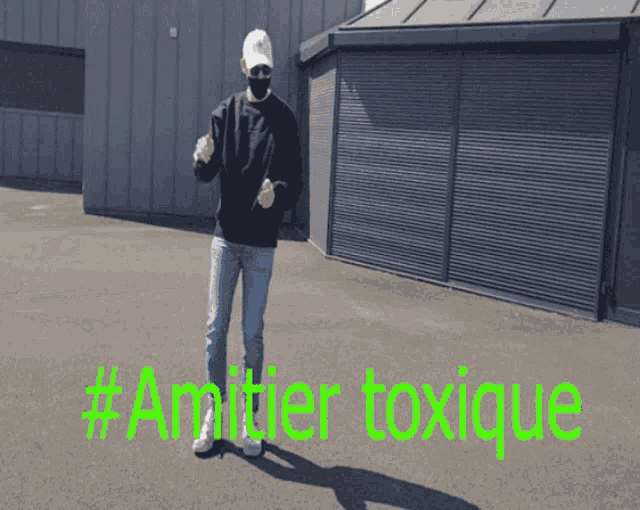 a man wearing a mask is standing in front of a building with the words # amplifier toxice written on the ground
