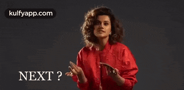 a woman in a red shirt is holding a cell phone and a piece of paper in her hands .