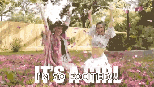 a couple of women are standing in a field of pink petals .