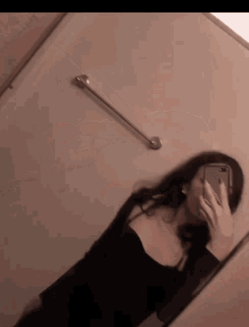 a woman is taking a picture of herself in the mirror