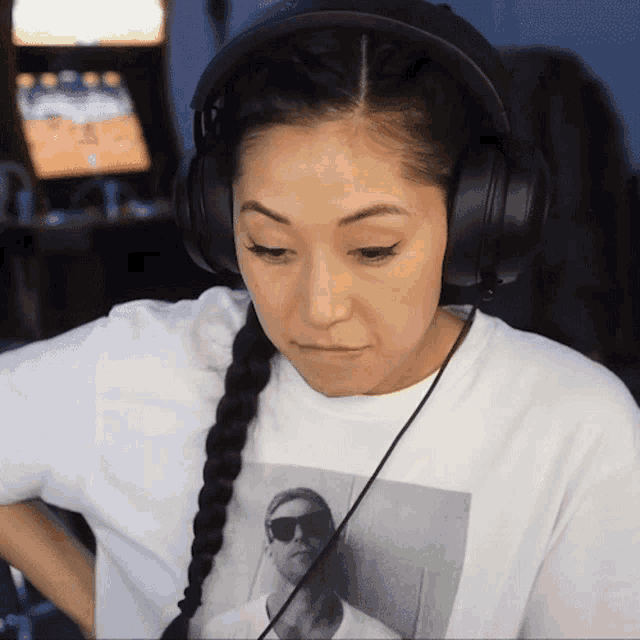 a woman wearing headphones and a white shirt with a picture of a man