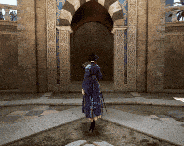 a woman in a blue dress is standing in front of a stone building