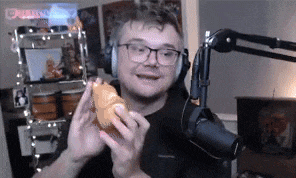 a man is eating a croissant in front of a microphone .