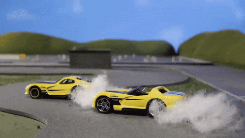 two yellow toy cars are racing on a road