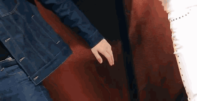 two people are holding hands with rings on their fingers while sitting on a couch .