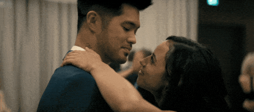 a man and a woman are dancing and the man has a tattoo on his neck that says " i love you "