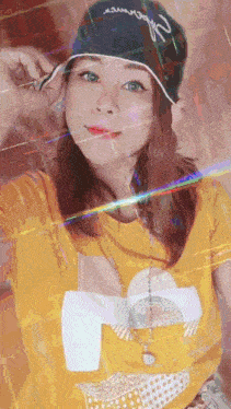a woman wearing a yellow shirt and a black hat with the word supreme on the front
