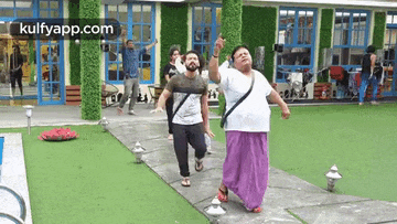 two men are dancing in front of a building .