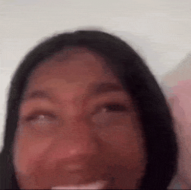 a close up of a woman 's face with her eyes closed and a toothbrush in her mouth .