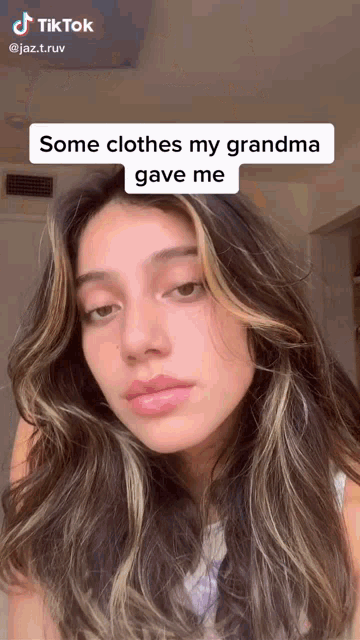 a woman is making a tiktok video about clothes her grandma gave her