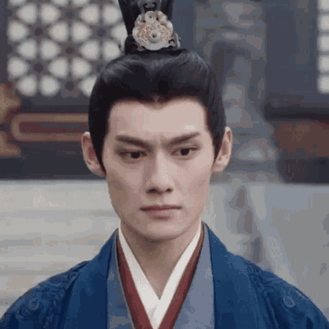 a close up of a man wearing a crown and a blue robe .