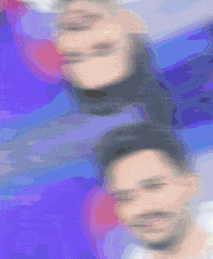 a blurry picture of a man and a woman 's faces on a purple background