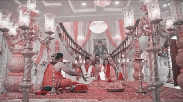 a group of people sitting on a stage with candles and flowers