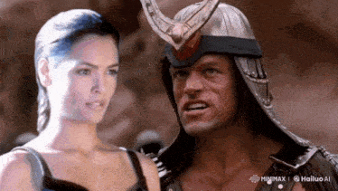 a man and a woman are standing next to each other and the man is wearing a helmet with horns on it .