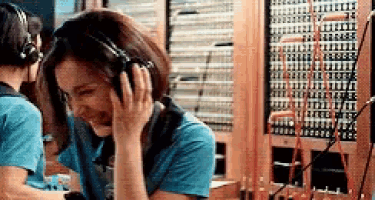 a woman is wearing headphones while talking on a phone .