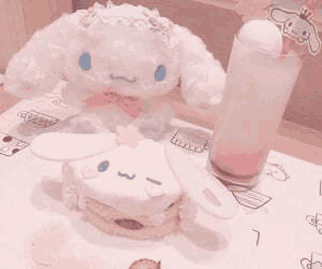 a stuffed animal is sitting on a table next to a sandwich and a glass of pink liquid .