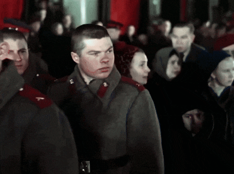 a man in a military uniform stands in front of a crowd of people