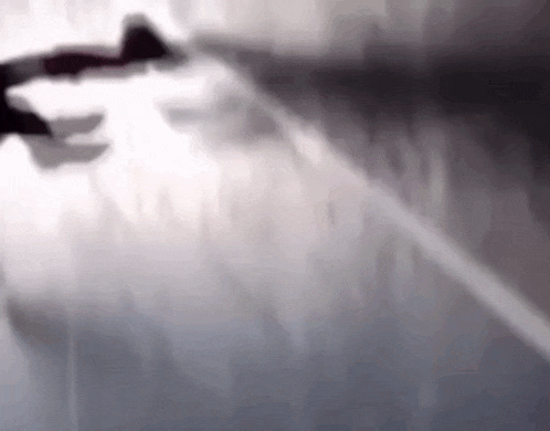 a blurred image of a plane flying over a city .