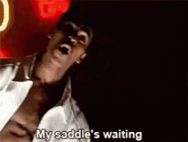 a man in a white shirt is talking about his saddle 's waiting .