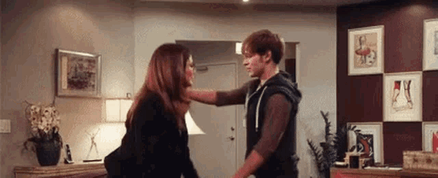 a man and woman are dancing in a living room .