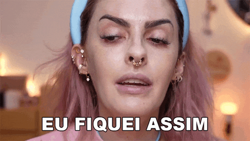 a woman with pink hair is wearing a blue headband and earrings and says eu fiquei assim
