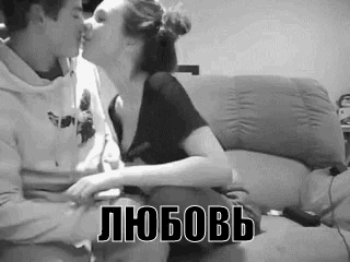 a man and a woman are kissing on a couch in a black and white photo with russian writing .