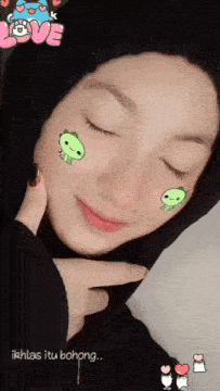a woman with her eyes closed has a sticker on her face that says " love "