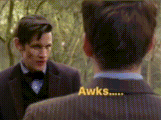 a man in a suit and bow tie is talking to another man with the words awks written on the back of his suit