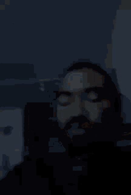 a man with a beard and mustache is making a funny face .