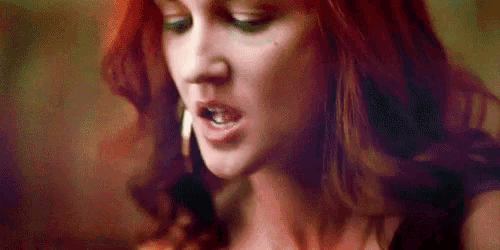 a close up of a woman with red hair making a face .