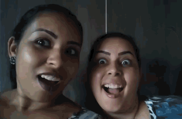 two women are posing for a picture with their mouths open .