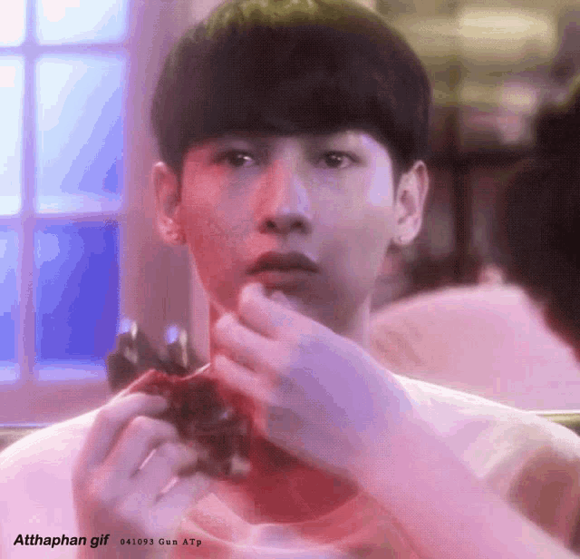 a young man is looking at himself in a mirror while eating a candy bar .