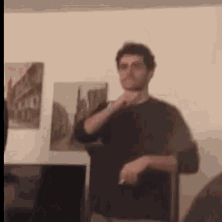 a man in a black shirt is standing in a living room .