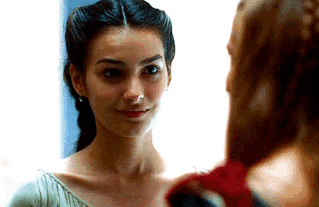 two women are looking at each other and one of them is wearing earrings