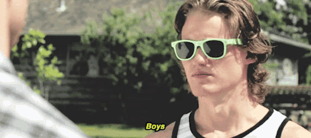 a man wearing green sunglasses is talking to another man who says " boys "